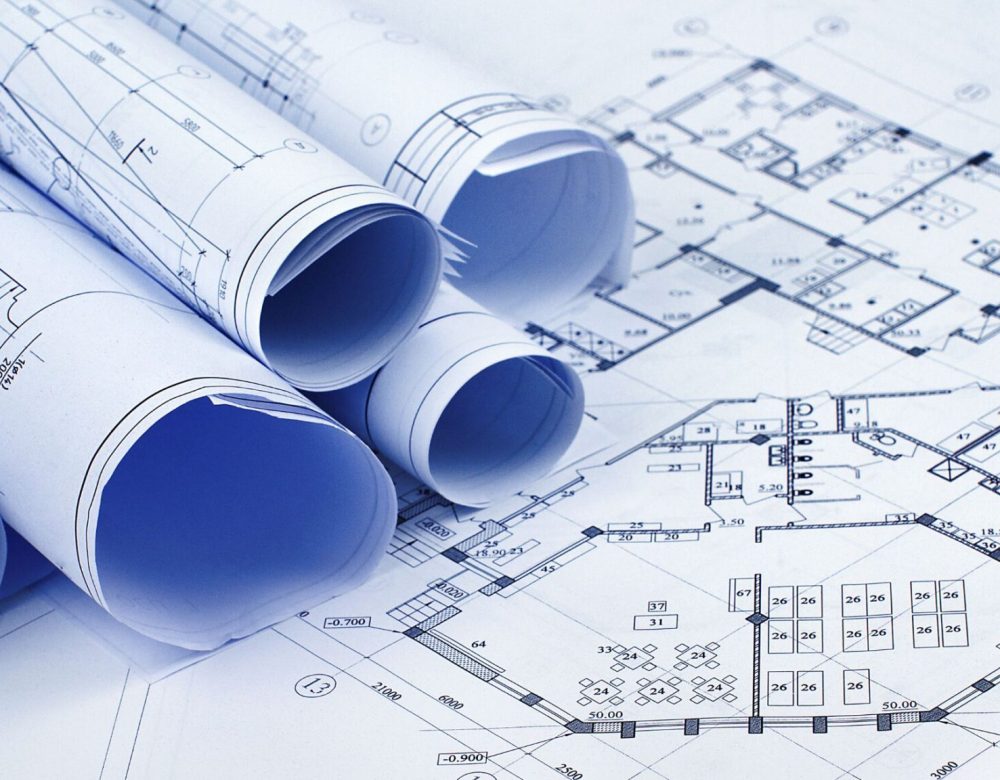 A Discovery Expert inspects underground infrastructure plans on a civil construction site.