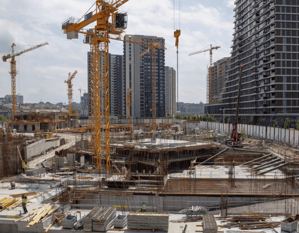 civil-heavy-underground-construction-site-delay Civil and underground construction site showing heavy equipment and marked utility zones indicating delay risks