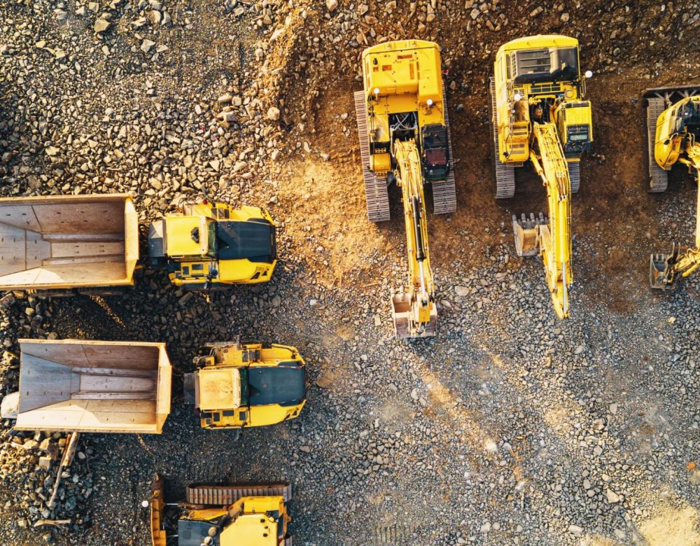 A construction site with various heavy equipment types (e.g., excavator, crane, and forklift) in operation